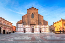 Photo of Italy Piazza Maggiore in Bologna old town tower of town hall with big clock and blue sky on background, antique buildings terracotta galleries.