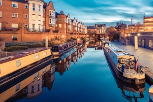 Photo of a narrow boat moored at the river Gade, Grand Union Canal. The Grove Bridge aka Grove Ornamental Bridge No 164 is in the background, Cassiobury Park, Watford, England.