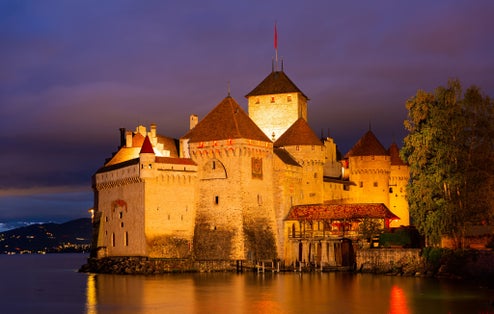 Photo of scenic view of architectural complex of fortified Chillon Castle on Lake Geneva at summer dusk, Switzerland.