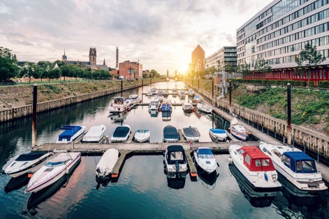 Photo of Duisburg Marina with ships and modern buildings, Germany.