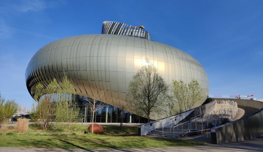 Exterior of La Cité du Vin in Bordeaux, a modern wine museum with a curved metallic facade and clear blue sky..jpg
