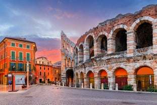 Photo of Italy Piazza Maggiore in Bologna old town tower of town hall with big clock and blue sky on background, antique buildings terracotta galleries.