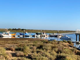 Photo of aerial cityscape of beautiful Tavira with roman bridge over Gilao river in the evening, Algarve, Portugal.