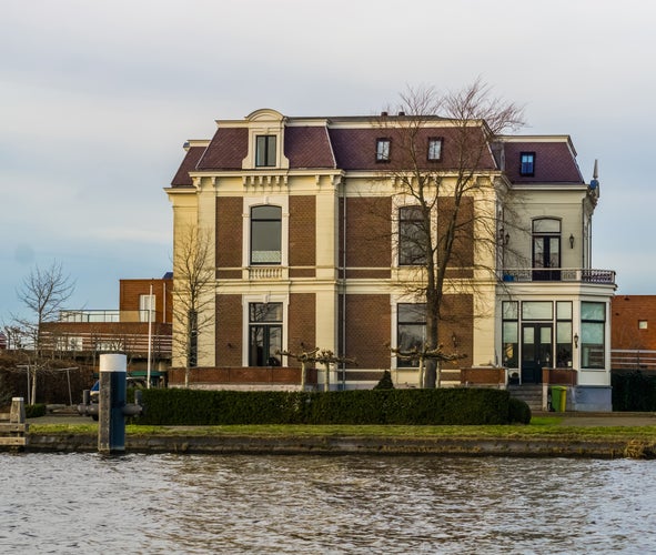 photo of view of big and luxurious country house at the water side, city architecture of Alphen aan den Rijn, The Netherlands.