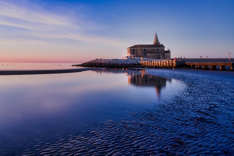 Photo of Caorle the little Venice Beaches with beautiful colorful sunset, historic center and promenades along the sea