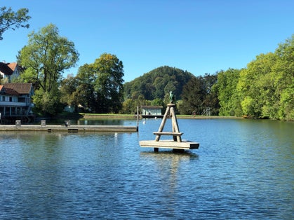 photo of people enjoying the view of the lake Mannenweier pond its three ponds recreation Drei Weieren in St. Gallen, Switzerland.
