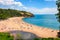 Photo of aerial view of sunny seascape with people enjoying the beach in Blackpool Sands, Devon, UK.