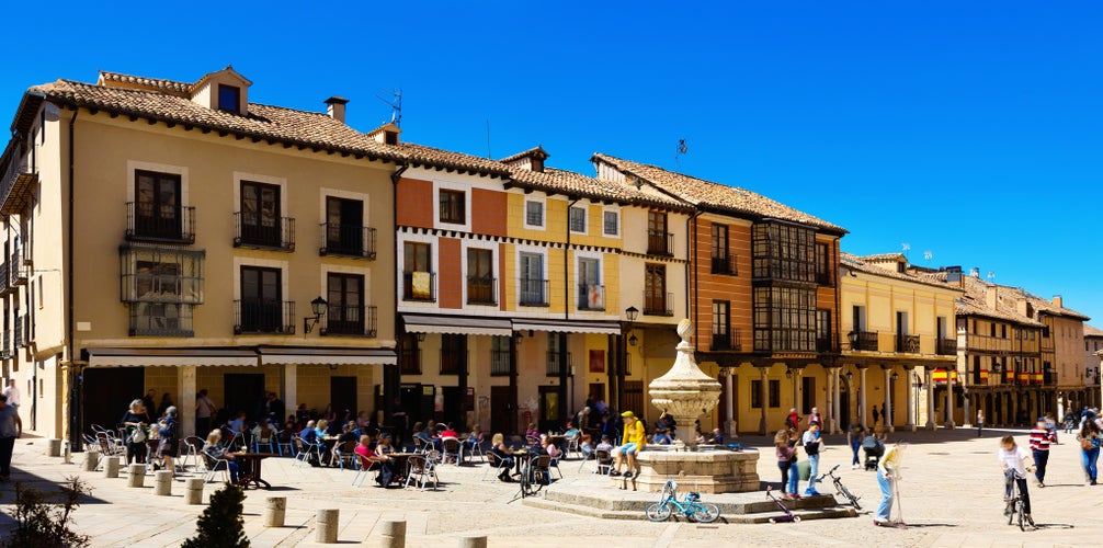 Photo of Streets of El Burgo de Osma, province of Soria, Spain. View of people sitting at tables in outdoor cafe near fountain.