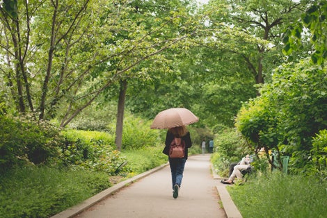 photo of a woman walking through the Promenade Plantée, also known as Coulée Verte, translated as “Tree-lined walkway” in Paris, France.