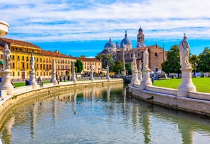 Photo of beautiful view of canal with statues on square Prato della Valle and Basilica Santa Giustina in Padova (Padua), Veneto, Italy.