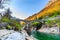 photo of two arches stone bridge soars over turquoise water stream of Valle Verzasca named Ponte dei Salti in canton of Ticino, Switzerland.