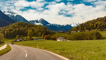 photo of Elevated, scenic view of the town of Bischofswiesen, Bavaria, Germany. The Watzmann Mountain, part of the Bavarian Alps rises into a majestic skyline. A green, spring landscape set in the valley.