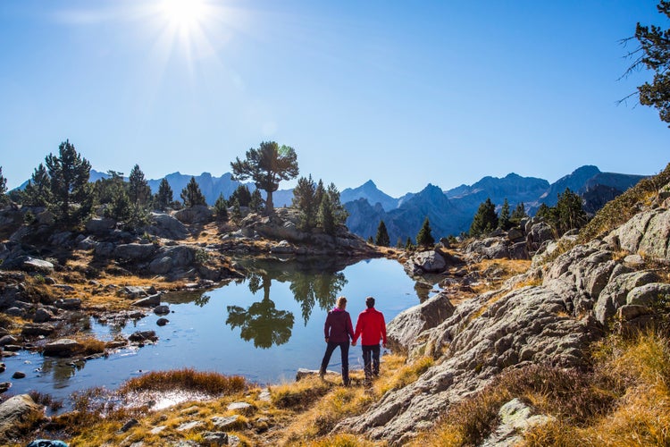 Photo of Young hiker couple in autumn in Aiguestortes and Sant Maurici National Park, Pyrenees, Spain.