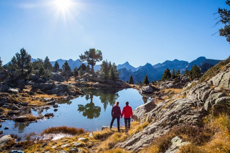 Photo of Young hiker couple in autumn in Aiguestortes and Sant Maurici National Park, Pyrenees, Spain.
