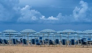 Photo of beach chairs, on a sandy, shoreline, in Giulianova, Italy.