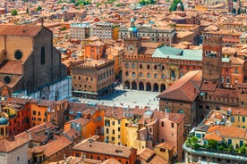 Photo of Italy Piazza Maggiore in Bologna old town tower of town hall with big clock and blue sky on background, antique buildings terracotta galleries.