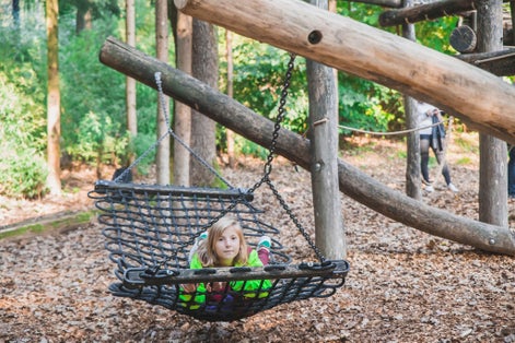 Teenage girl swinging on a swing at the Ljubljana Zoo