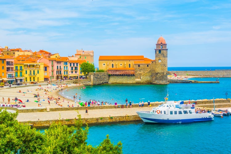 Photo of church of Our Lady of the Angels with view of beautiful beach in Collioure, on the shores of the Mediterranean Sea.