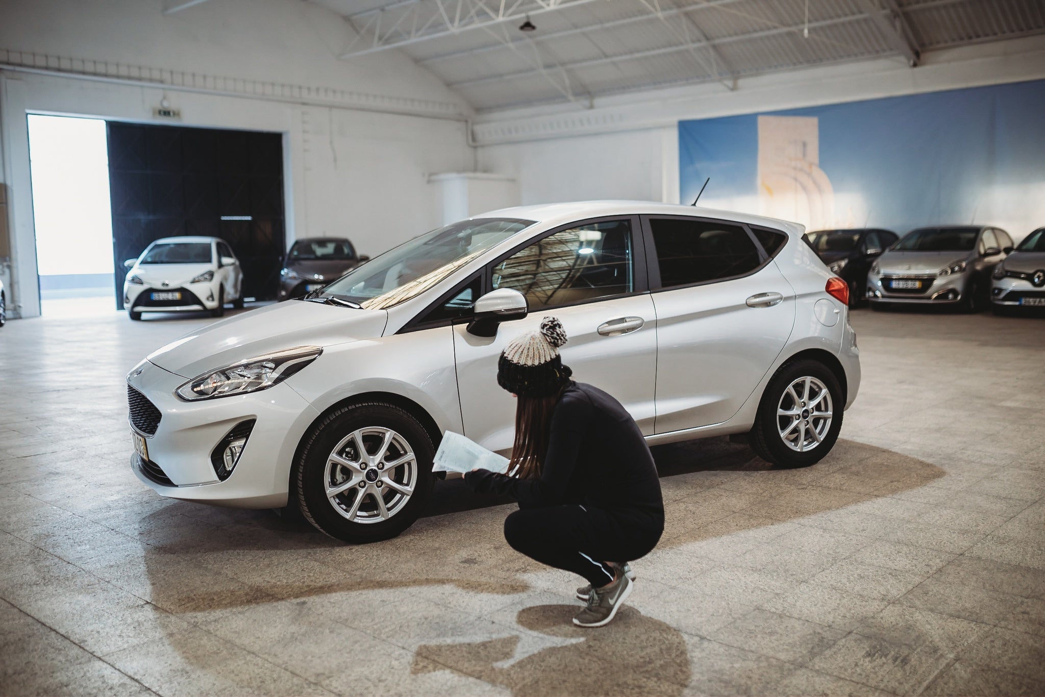 Lisbon, Portugal. January 12th 2019. Young woman checking rental car in warehouse.jpg