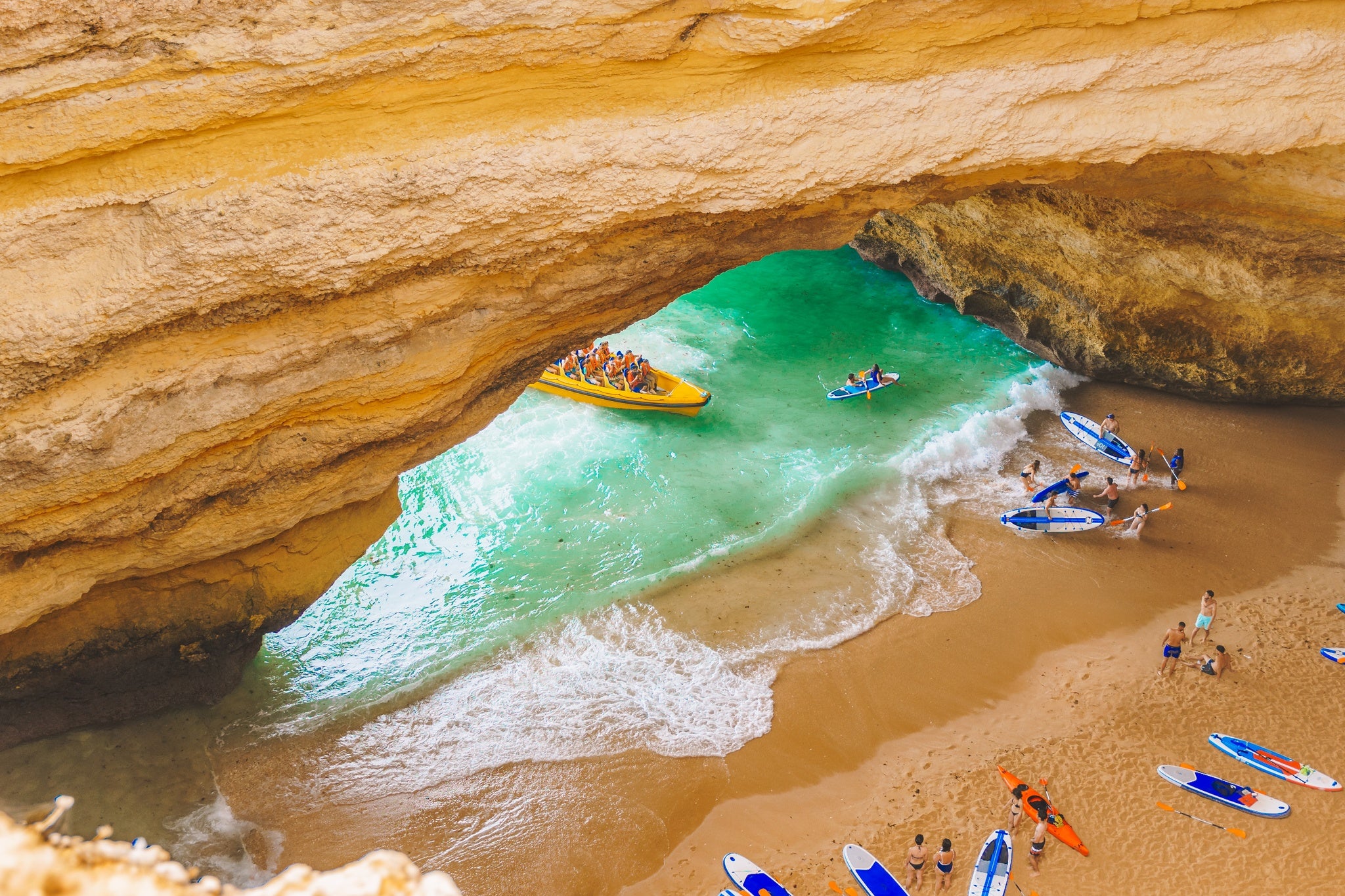 Benagil cave in Portugal, Carvoeiro Algarve, Lagos. Tourists swimming on paddle boards for SUP, kayak, motor boats to Praia de Benagil.jpg