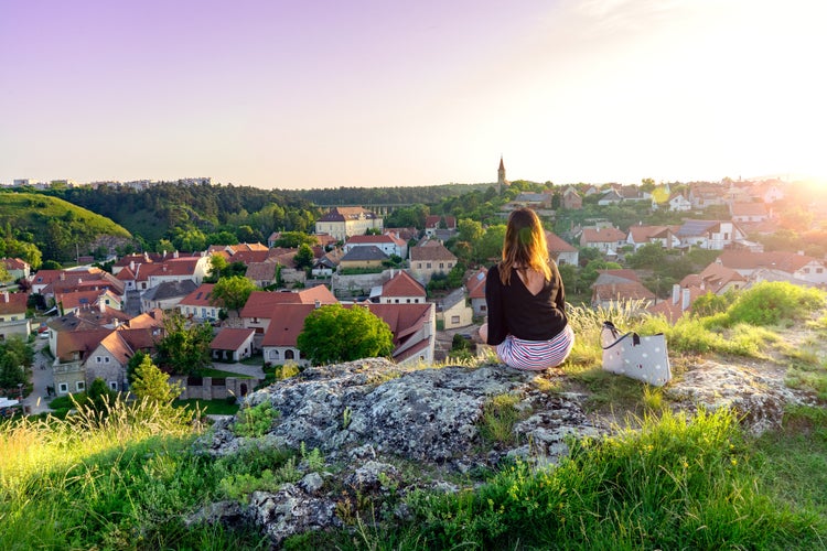 The green hill garden in the middle of old town Veszprém, Hungary with a woman sitting on the cliff enjoying the view