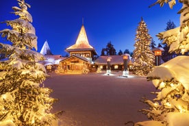 Photo of stunning sunset view over wooden huts and snow covered trees in Kuusamo, Finnish Lapland.