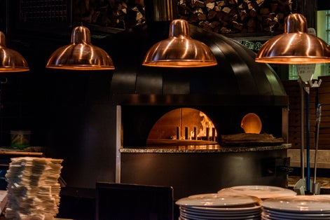 Photo of Old school pizza oven with fire burning in it. Time Out Market in Lisbon, Portugal.