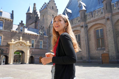 photo of young student girl visiting the complex of buildings of Binnenhof in the Hague, Netherlands.