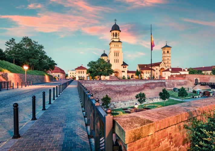 photo of view of Colorful cityscape of Fortified churches inside Alba Carolina Fortress. Great sunset in Transylvania, Alba Iulia city, Romania, Europe. Traveling concept background.