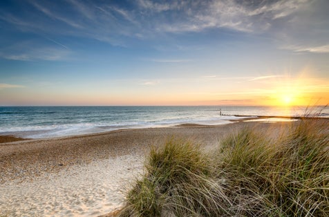 Photo of sunset over sand dunes at Hengistbury Head beach near Bournemouth in Dorset.