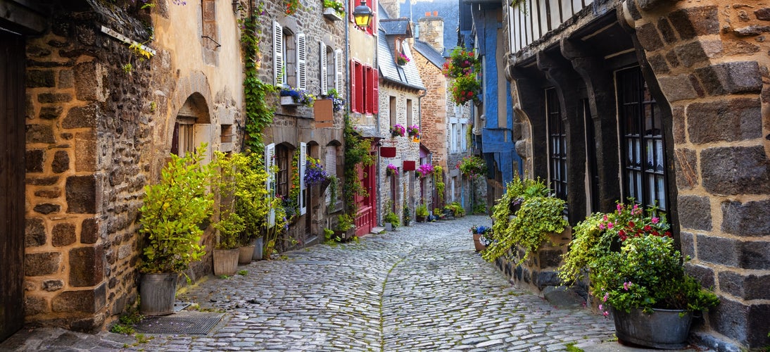 photo of view of Dinan, traditional colorful houses on a cobbled street in medieval town center, Brittany, France.