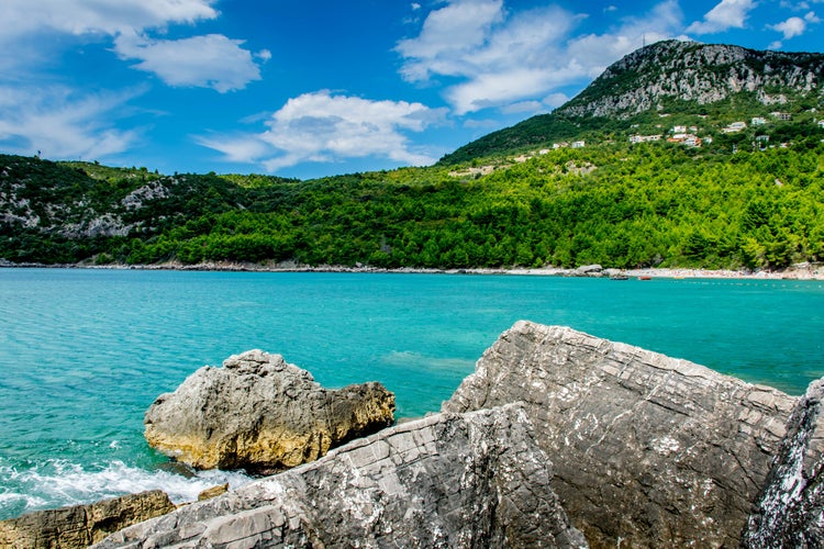 Photo of Montenegro coast seascape with perfect blue water with mountains around, blue sky near Bar town.