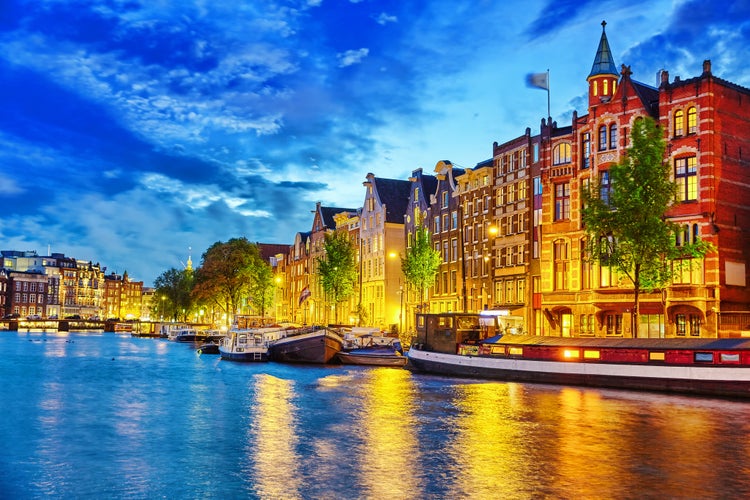 photo of famous Amstel river and night view of beautiful Amsterdam city, Netherlands.