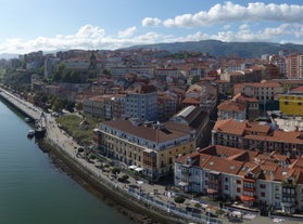 Photo of aerial view of Vizcaya bridge over the river and cityscape at Portugalete, Spain.