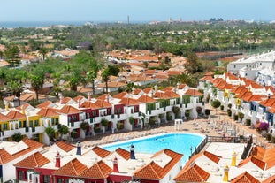 photo of landscape with Maspalomas town and golden sand dunes at sunrise, Gran Canaria, Canary Islands, Spain.