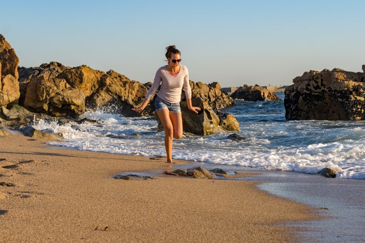 A young beautiful woman runs around the Atlantic coast in Portugal and enjoys life