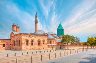 Touristic sightseeing ships in Golden Horn bay of Istanbul and mosque with Sultanahmet district against blue sky and clouds. Istanbul, Turkey during sunny summer day.