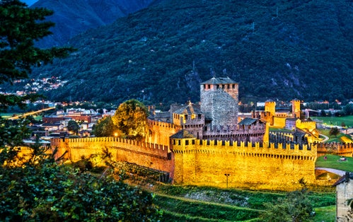 photo of evening view of Montebello and Castelgrande, castles in Bellinzona. UNESCO world heritage in Ticino, Switzerland.