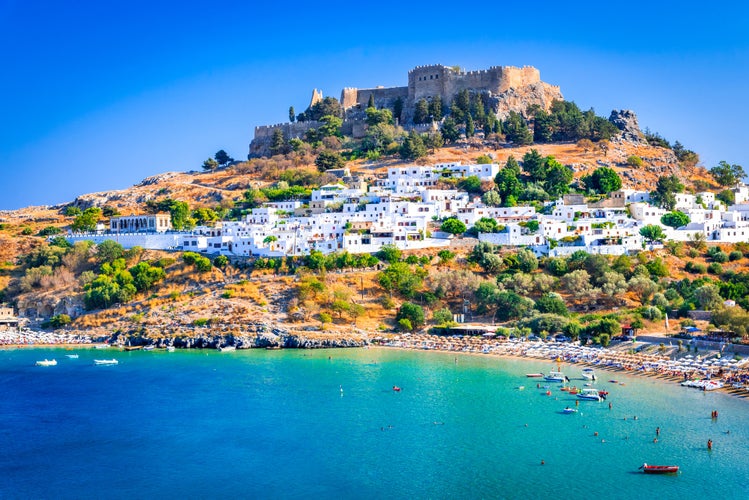 Photo of landscape with beach and castle at Lindos village of Rhodes, Greece.