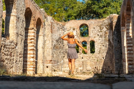 Photo of woman tourist walking in Great basilica in Butrint National Park, Albania.