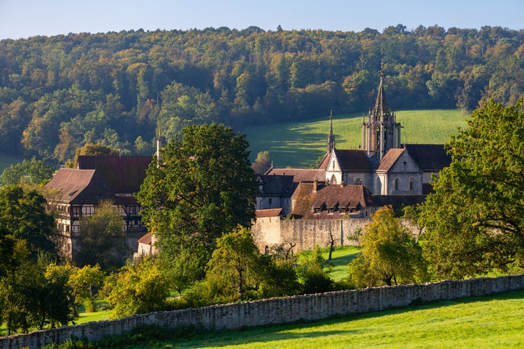 “Kloster Bebenhausen“ monastery and castle near Tübingen in southern Germany on a sunny late summer morning. Medieval landmark monument and tourist attraction with church tower and truss houses.