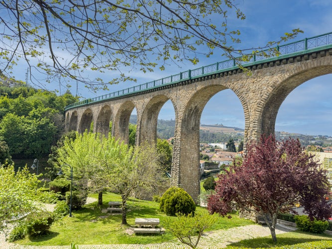 Photo of Old railway bridge and garden in Vouzela, Viseu, Portugal, on a sunny afternoon.