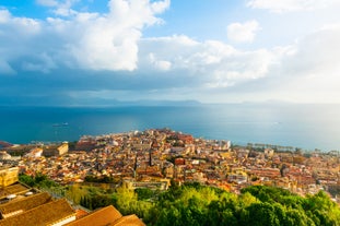 Naples, Italy. View of the Gulf of Naples from the Posillipo hill with Mount Vesuvius far in the background and some pine trees in foreground.