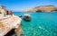 photo of view of Matala beach with small fishing boats and cave ,Mátala Greece.s on the rocks that were used as a roman cemetery and at the decade of 70's were living hippies from all over the world, Crete, Greece,