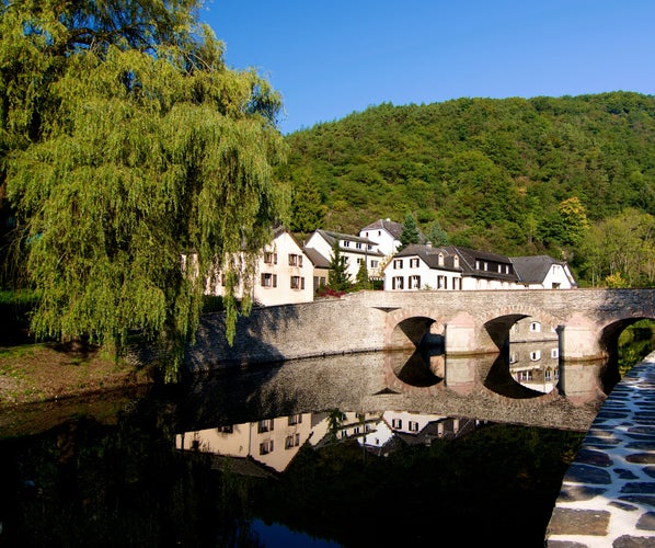 Medieval Village Esch sur Sure with Classical Houses and Bridge over Reflection in Sunny Day on Blue Sky background Outdoors. Diekirch, Luxembourg