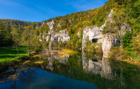 Panoramic view of Danube river valley near Sigmaringen, Germany. Limestone cliffs, colorful foliage and clear water reflecting idyllic scenery. Road between Dietfurt and Gutenstein with tunnels.