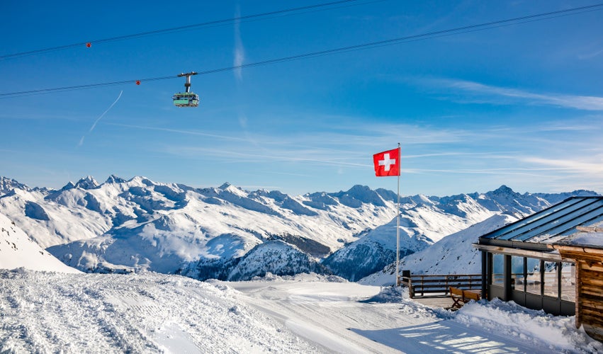 photo of red Swiss flag over Davos mountains, Switzerland.