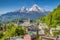 photo of historic town of Berchtesgaden with famous Watzmann mountain in the background on a sunny day with blue sky and clouds in springtime, National Park Berchtesgaden Land, Upper Bavaria, Germany.