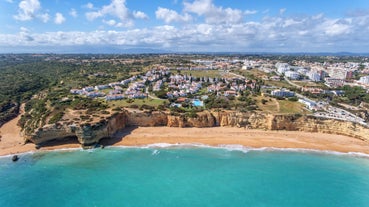 photo of an aerial view of wide sandy beach in touristic resorts of Quarteira and Vilamoura, Algarve, Portugal.