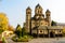 photo of view of Maria Laach Abbey in Germany. Autumn landscape. The medieval church in autumn forest, Gless, Germany.